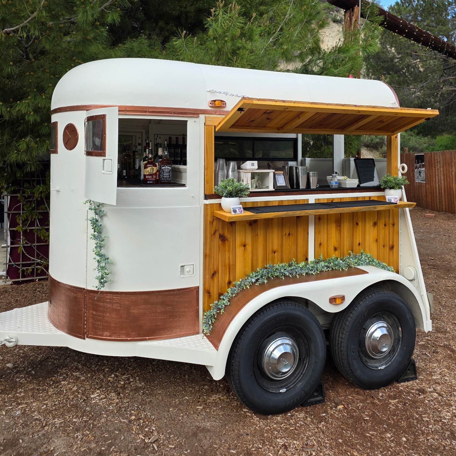 The Lucky Penny - a white and copper converted horse trailer mobile bar by Wandering Spirits, featuring cedar wood accents and a penny-topped bar counter.