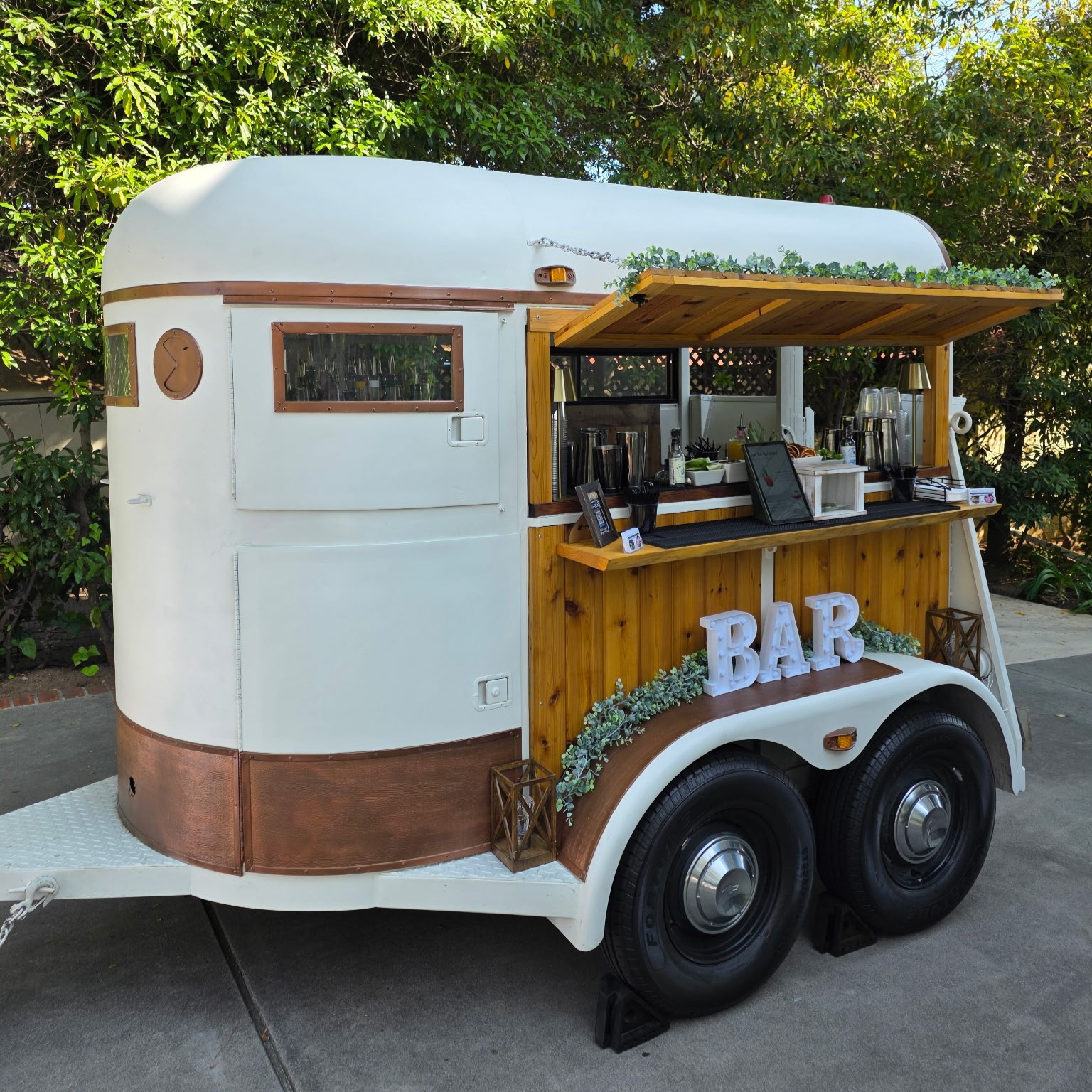 The Lucky Penny - a white and copper converted horse trailer mobile bar by Wandering Spirits, featuring cedar wood accents and a penny-topped bar counter.